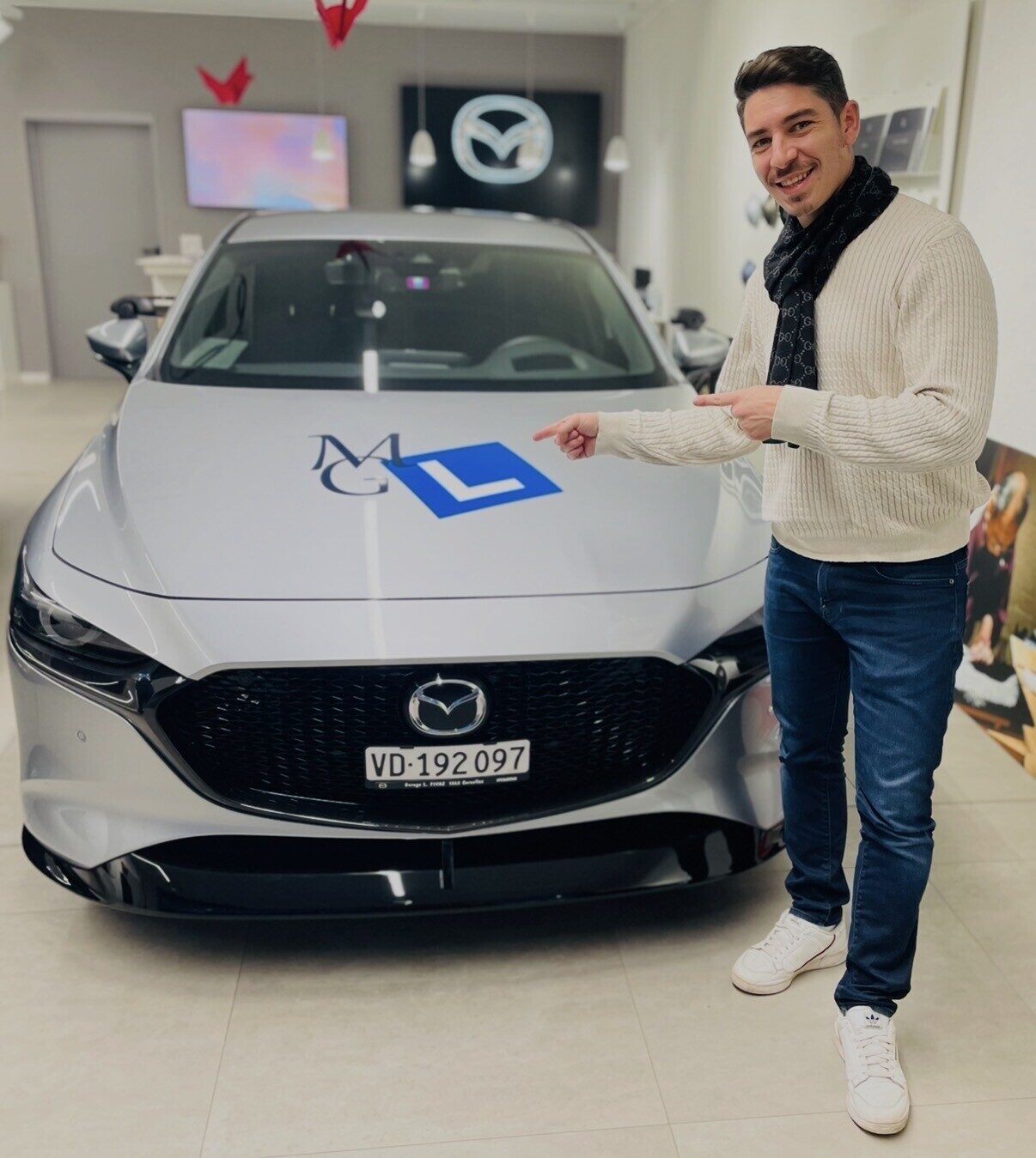 Mikael Ganhão devant la Mazda 3 de l'auto-école MG-L